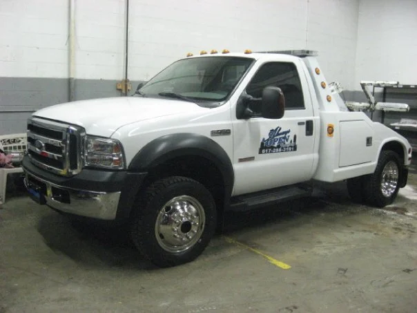Always Open Towing wrecker with the company phone number on the door